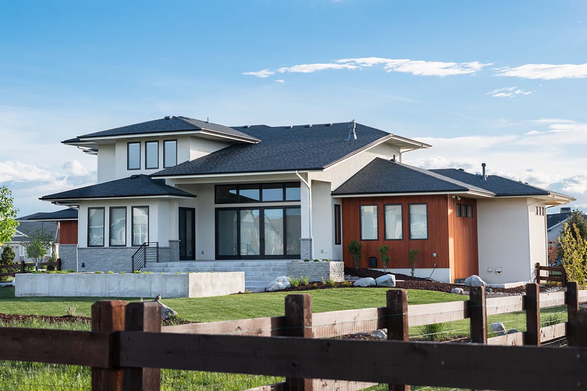 Modern house plan exterior with multiple rooflines, large windows, stucco, and wood siding.