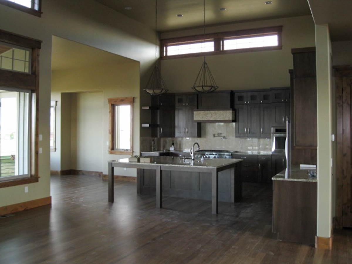 Open concept living area featuring a kitchen with dark wood cabinets, large island, and stainless steel appliances.