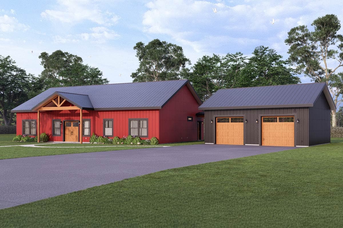 A red house with a black roof and a detached garage next to it; both have a modern barn style. A driveway leads to the house.