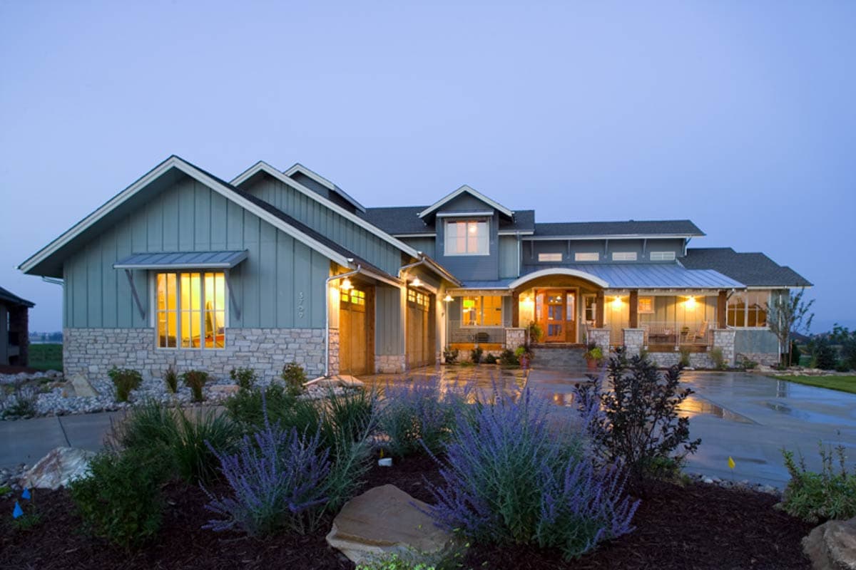 House plan exterior: Modern Farmhouse style, two-story, side-entry garage, stone foundation, gabled dormers, and covered front porch.