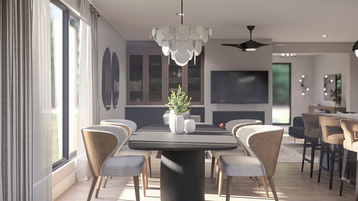 Dining area with pedestal table and chairs, fireplace, and bar seating with pendant lights.