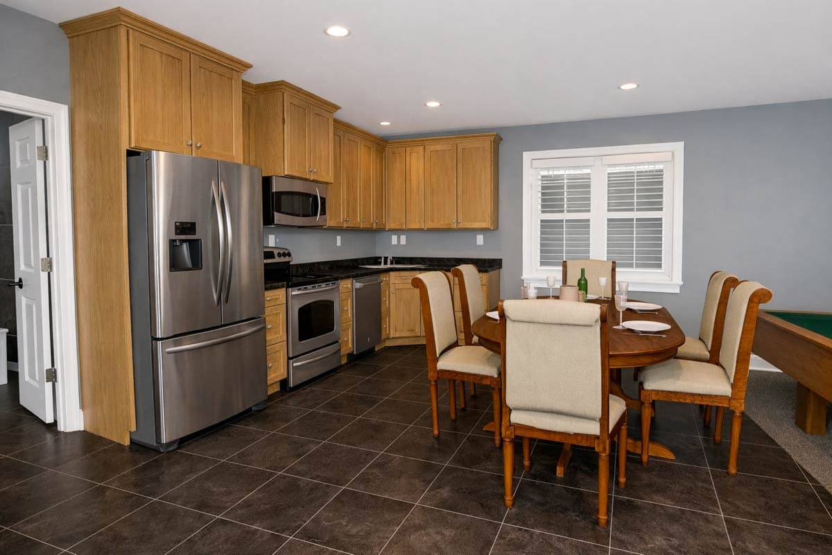 Kitchen with oak cabinets, stainless steel appliances, and dining table with chairs. Floor plan shows L-shaped counter.
