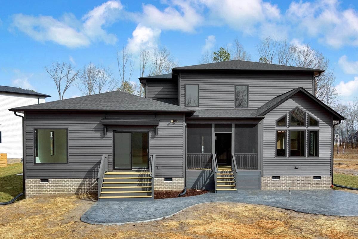 House plan exterior: Two-story residence with gray horizontal siding, screened porch, and arched window feature.