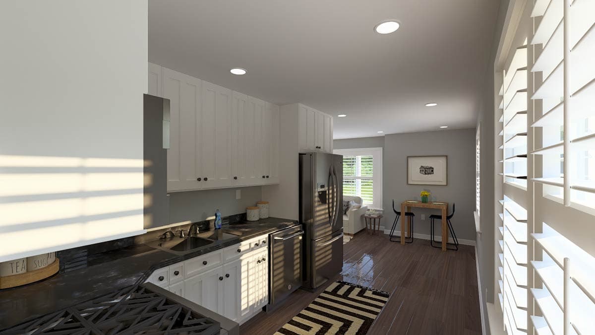 Kitchen with white cabinets, stainless steel appliances, sink, and dining area with small table and chairs visible.
