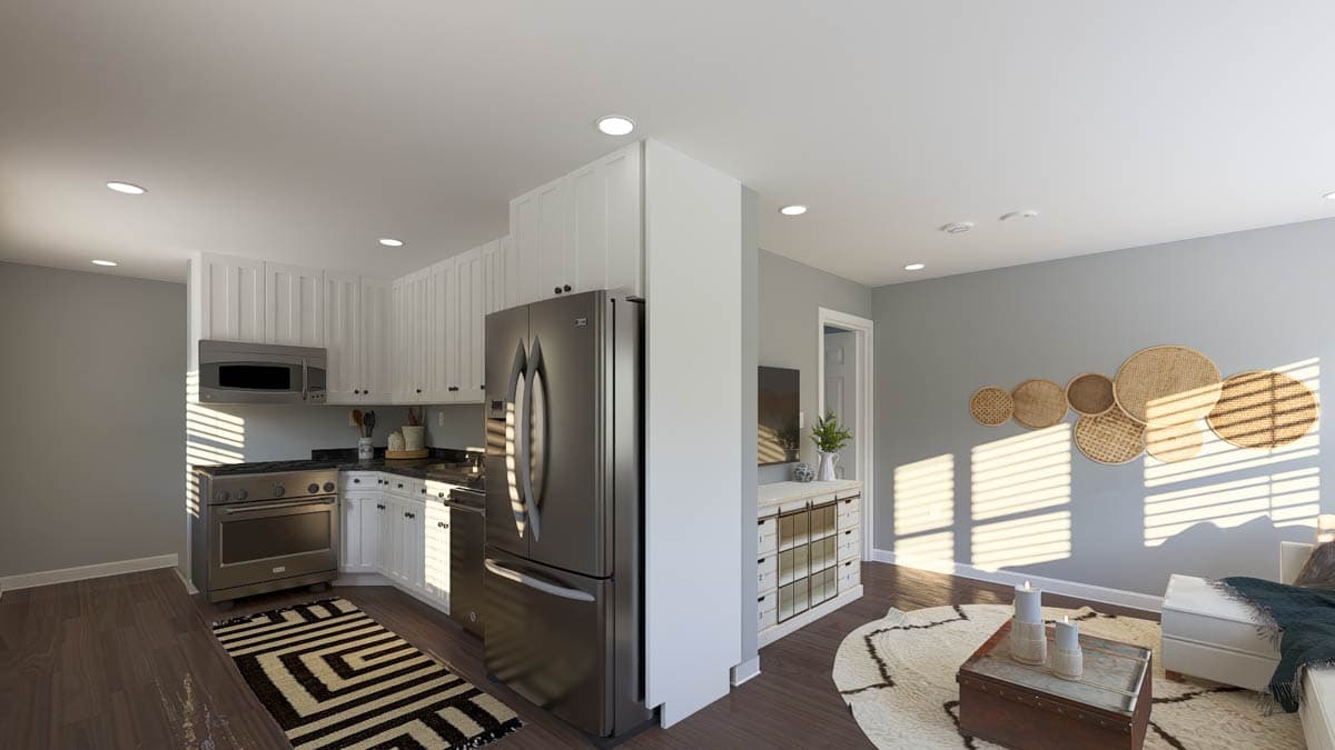 Open concept kitchen with white cabinetry and stainless steel appliances, adjacent to a living area with decorative wall art.