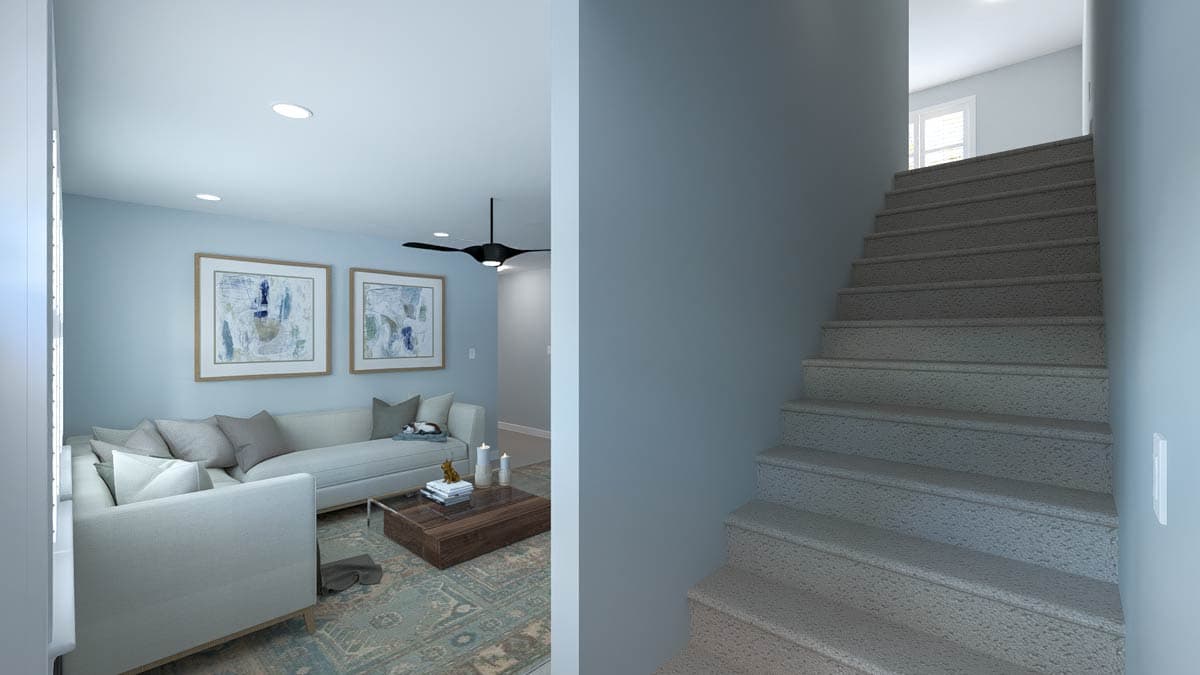 Living area with sofa and coffee table, adjacent to carpeted stairs leading upstairs. Recessed lighting.