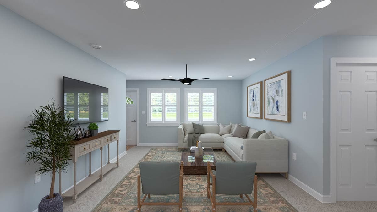 Living room with sectional sofa, coffee table, two armchairs, entertainment console with TV, and ceiling fan.