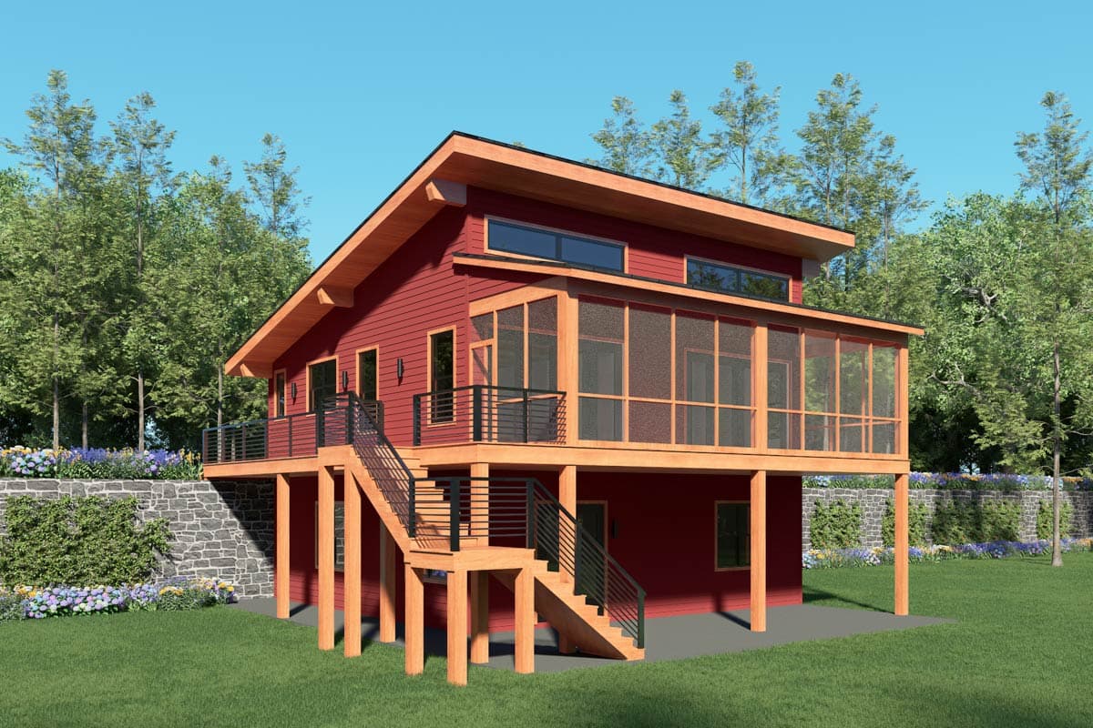 A two-story red house with a screened-in porch and an outdoor staircase, built on wooden stilts. Trees and green grass surround the house.