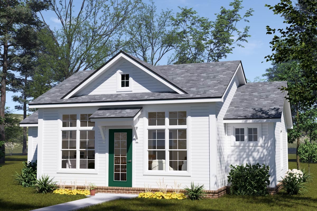 A white, two-story house with a green front door and multiple windows. The house sits on a green lawn with a tree-lined backdrop under a blue sky.