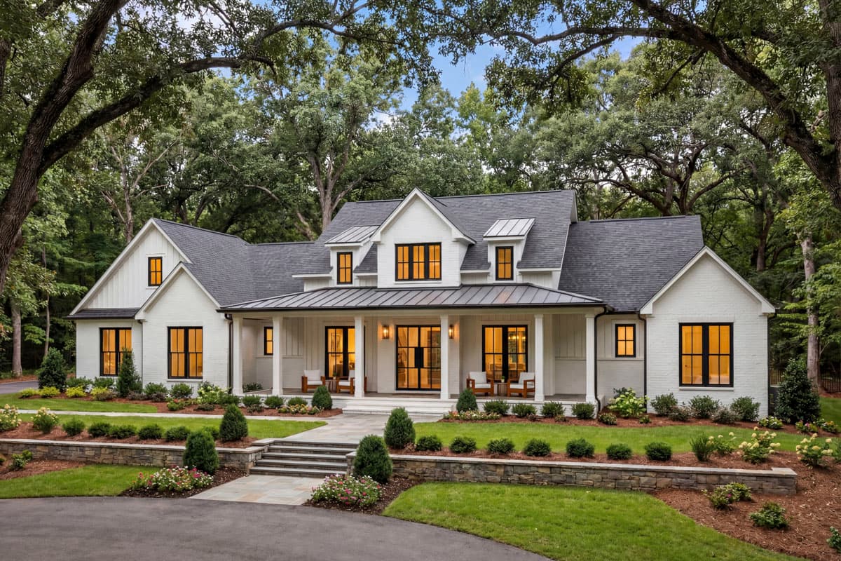 Modern Farmhouse house plan exterior with a wraparound porch, gables, dormers, and a metal roof.