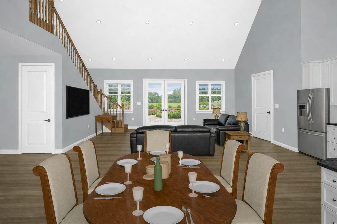 Open concept interior: dining area, living room with fireplace, staircase, and kitchen with stainless steel appliances.