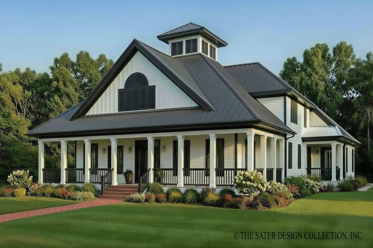 House plan exterior. Two-story farmhouse with a wrap-around porch, gabled roof, and cupola. Black shutters and a brick walkway are visible.