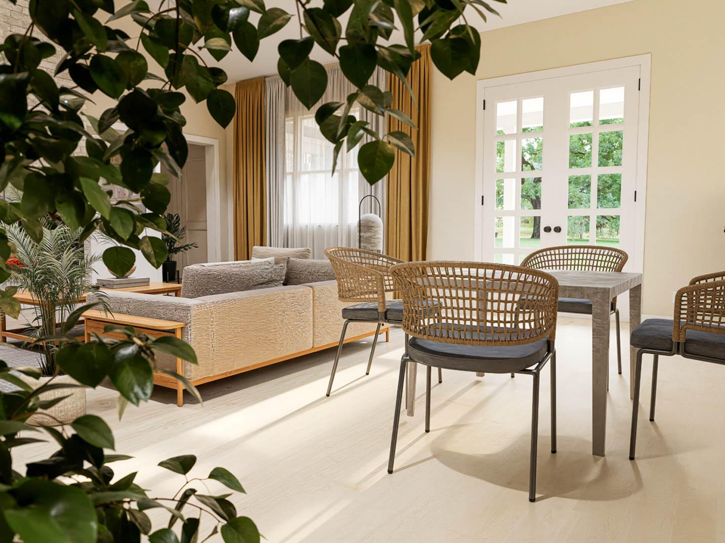 Interior view of a living and dining area with a sofa, dining table, chairs, and double doors to an exterior.