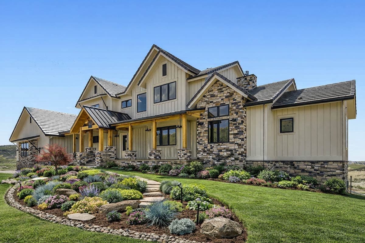 Modern Farmhouse house plan exterior with stone accents, prominent gables, a deep covered porch with timber supports, and multiple rooflines.