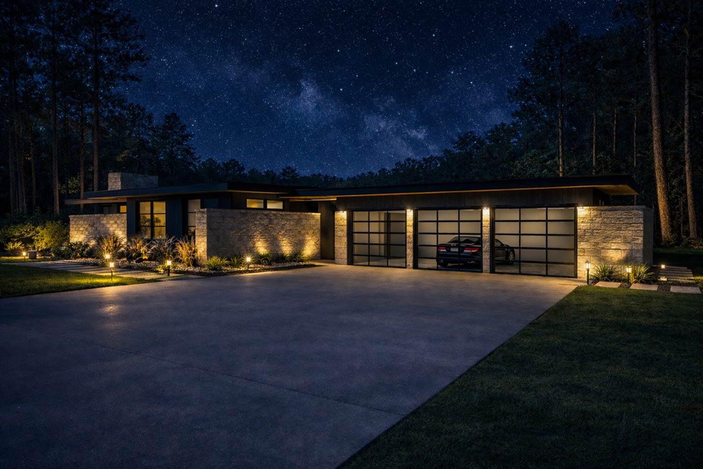 Modern house plan exterior with stone accents, flat roof, and a three-car glass garage door, illuminated at night.