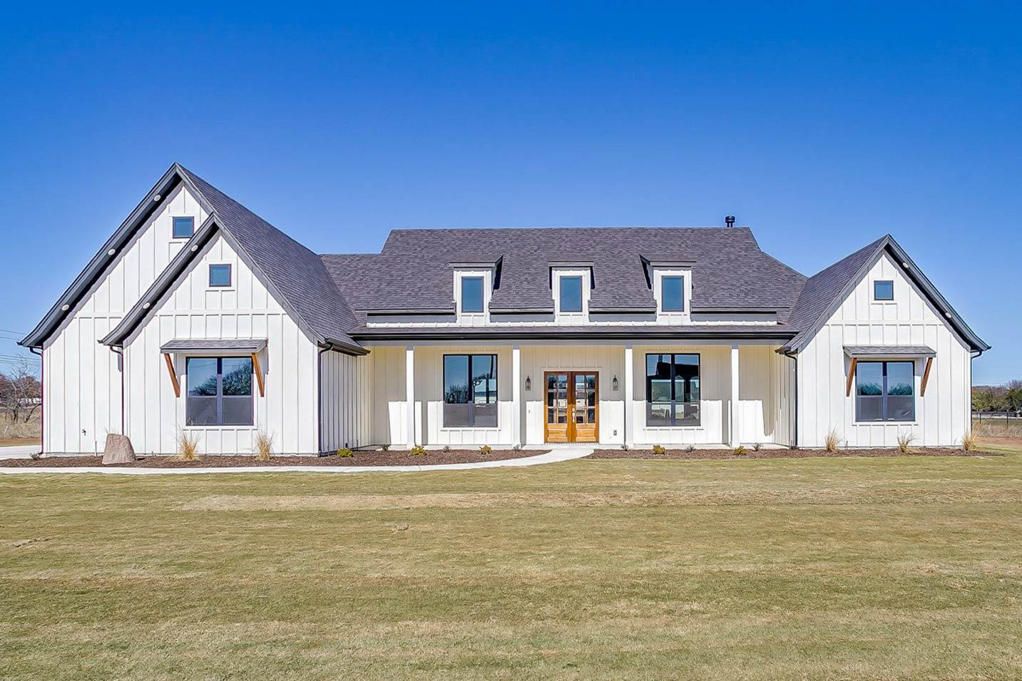 Modern Farmhouse house plan exterior with board and batten siding, gables, dormer windows, and a covered front porch.
