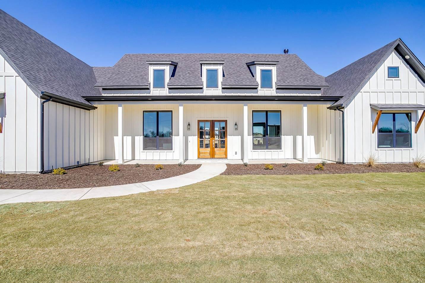Modern Farmhouse house plan exterior with board and batten siding, a covered porch, and three gables.