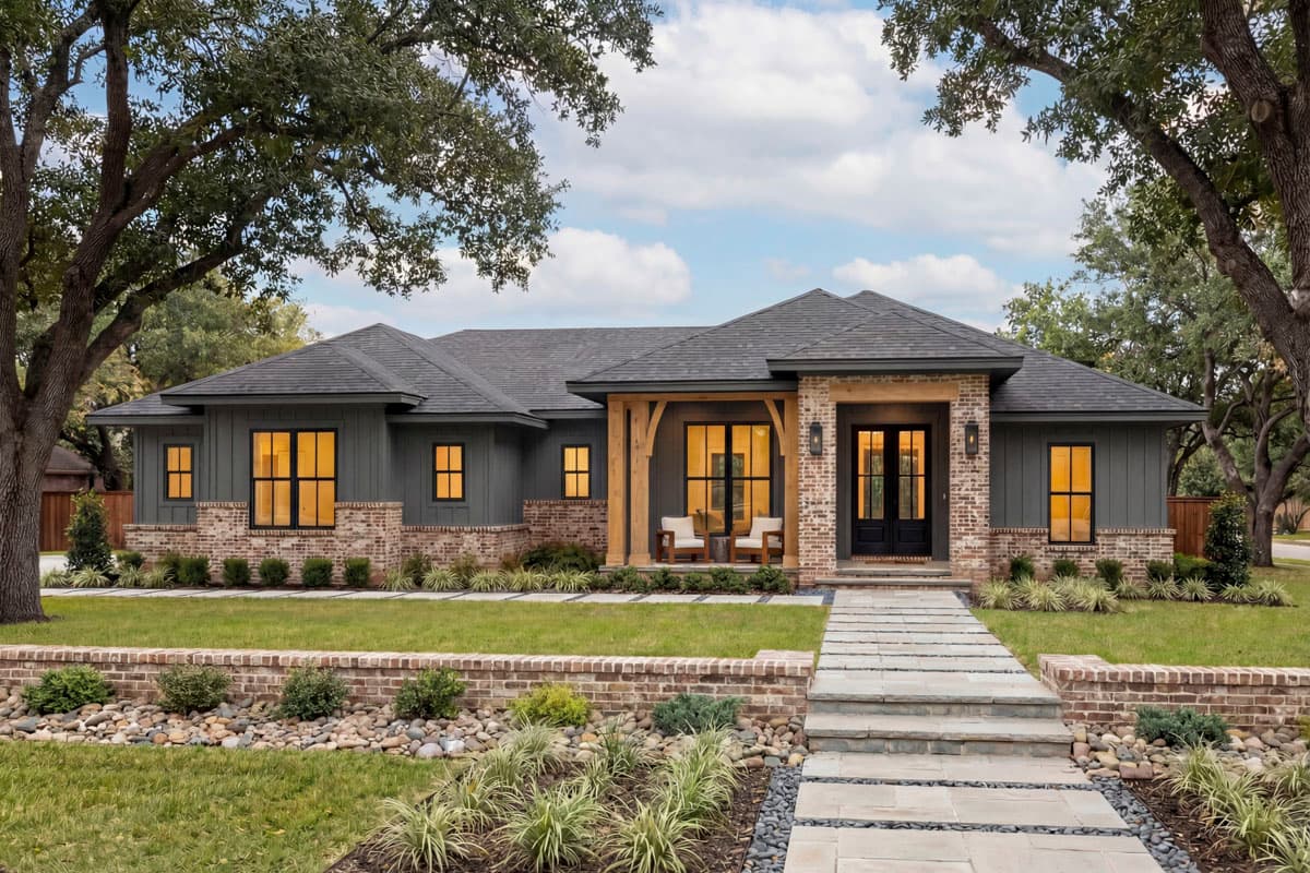 One-story Modern Farmhouse exterior with brick and board-and-batten siding, prominent gables, and covered entry with timber posts.