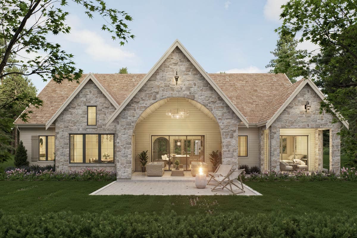 House plan exterior: Stone facade, arched covered patio, gabled rooflines, and multiple dormers. One story.