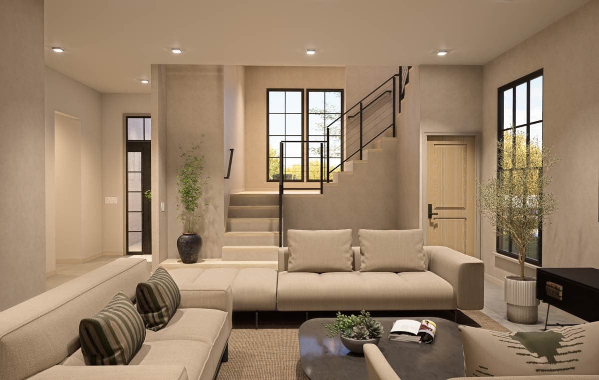 Modern living room with sectional sofa, open staircase with black railing, and large grid windows.