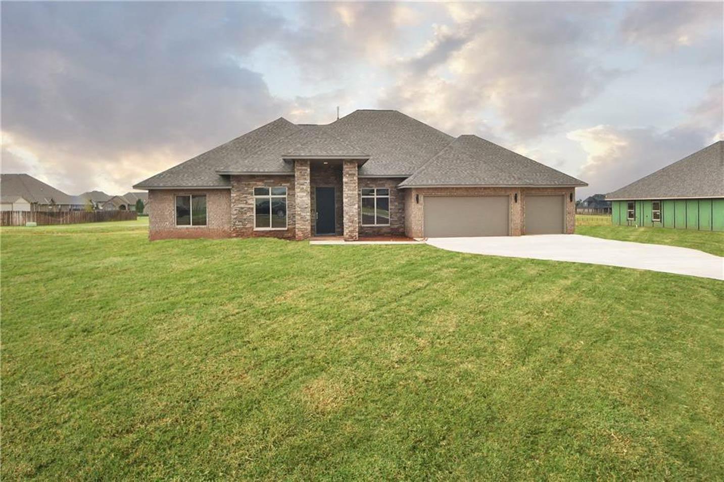 House plan exterior: single-story home with stone accents, a covered entry, and a three-car garage.