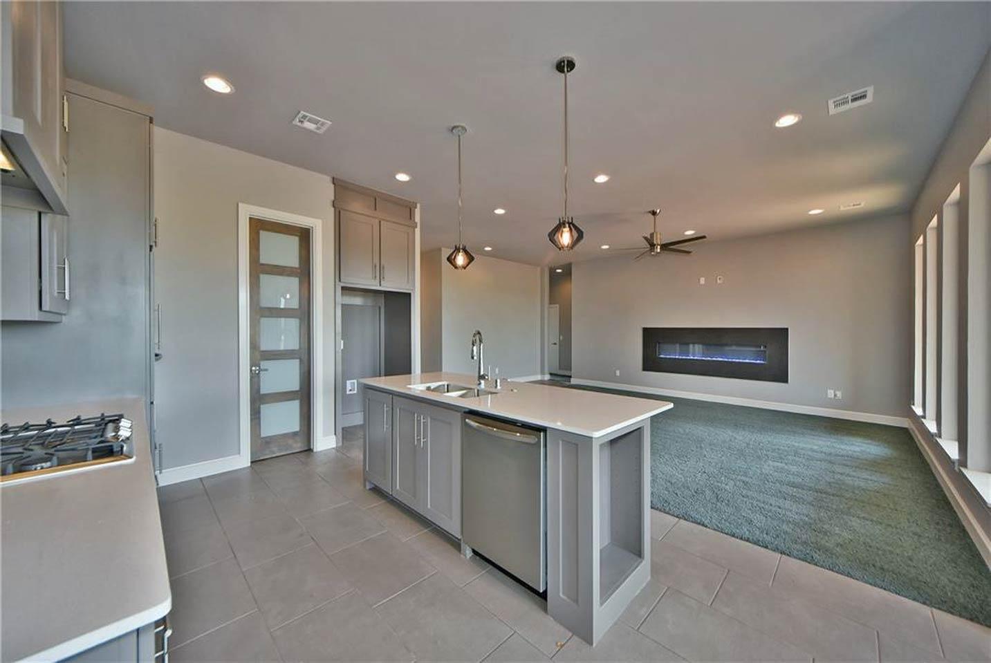 Interior rendering of open-concept living area with island kitchen, linear fireplace, and large windows.