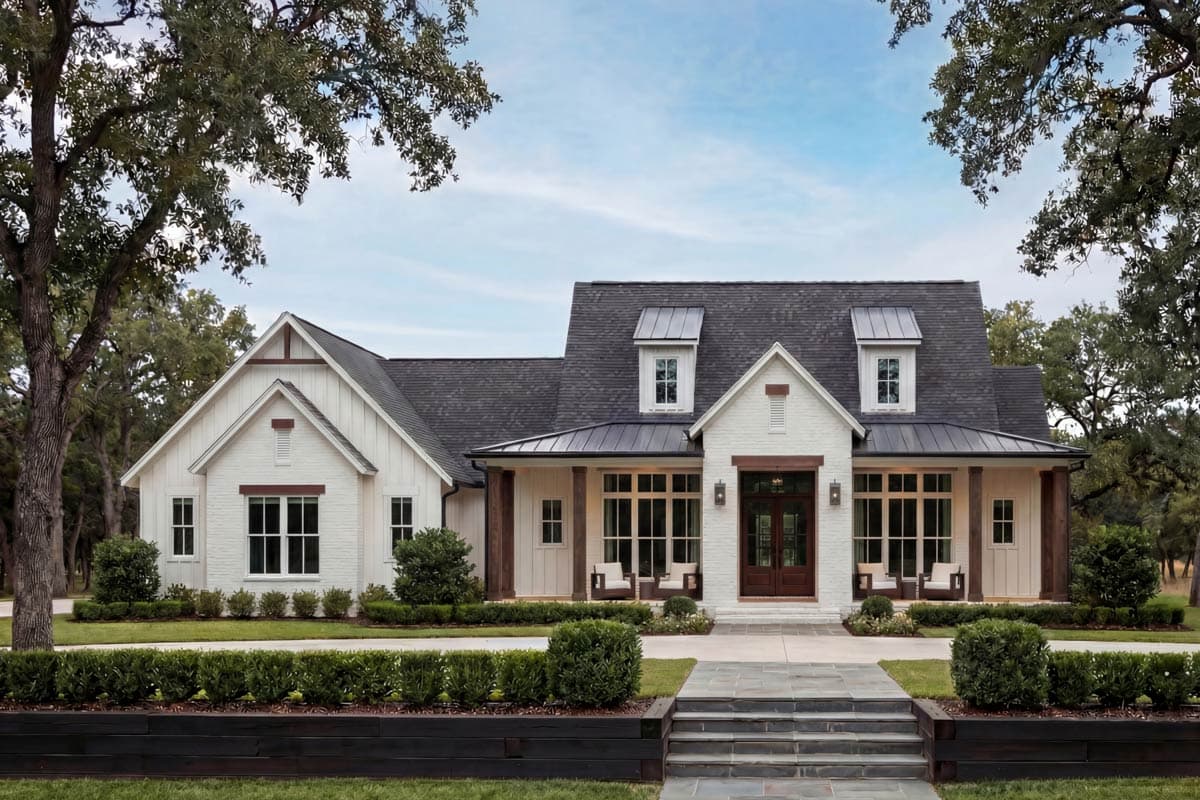 Modern Farmhouse house plan exterior with a wide covered porch, white brick and board-and-batten siding, and gable dormers.