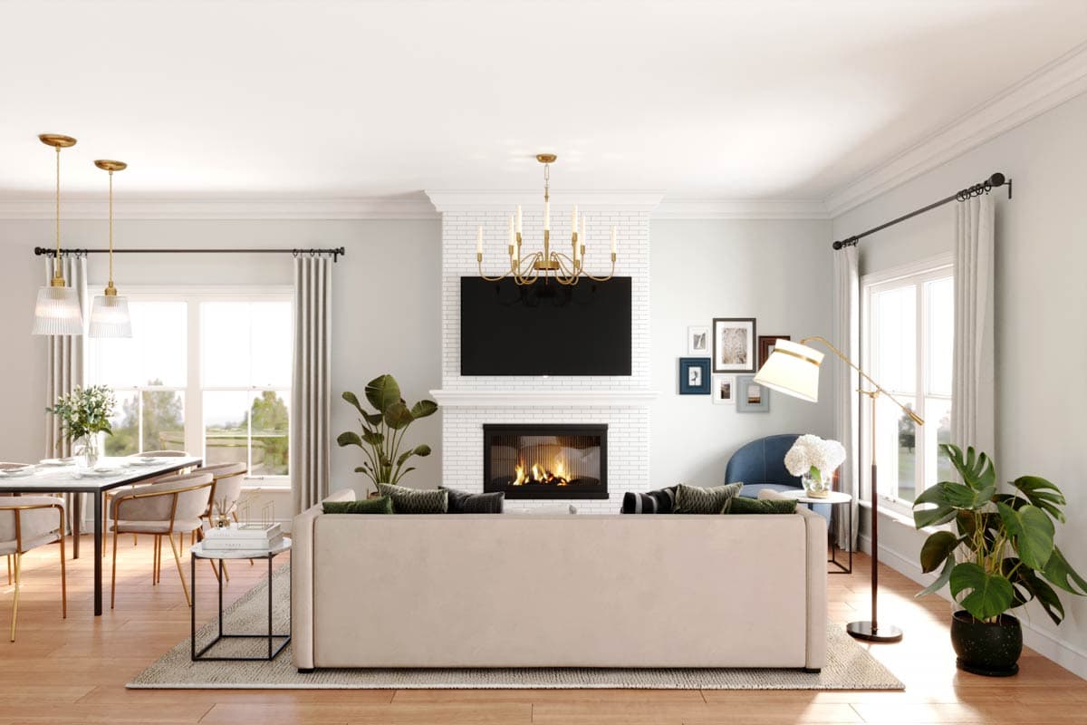 Interior view of a great room with a fireplace, television, sofa, dining area, and large windows.