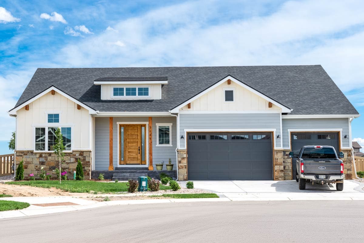 Modern Farmhouse house plan exterior with a covered front porch, dormer, and attached two-car garage.