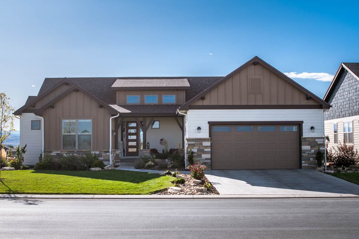 House plan exterior with a covered entry porch, gables, and a two-car garage. Modern Farmhouse style.