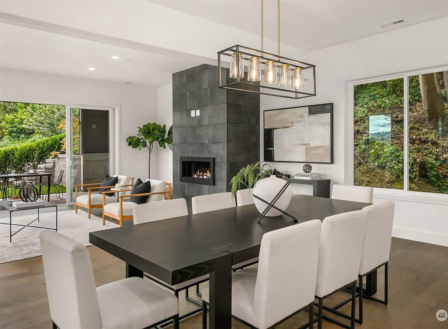 Dining area with a modern fireplace, large window, and access to an outdoor patio.