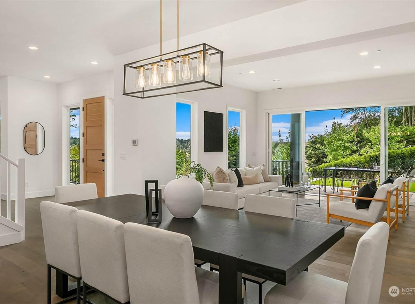 Dining and living areas with large windows, sliding glass doors, and an open layout.