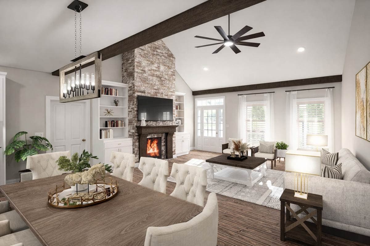 Open concept living area with vaulted ceiling, stone fireplace, large windows, dining area, and sectional sofa.