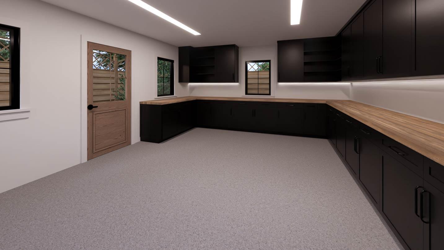 Garage interior with L-shaped workbench, dark cabinets, wood countertops, and two windows.