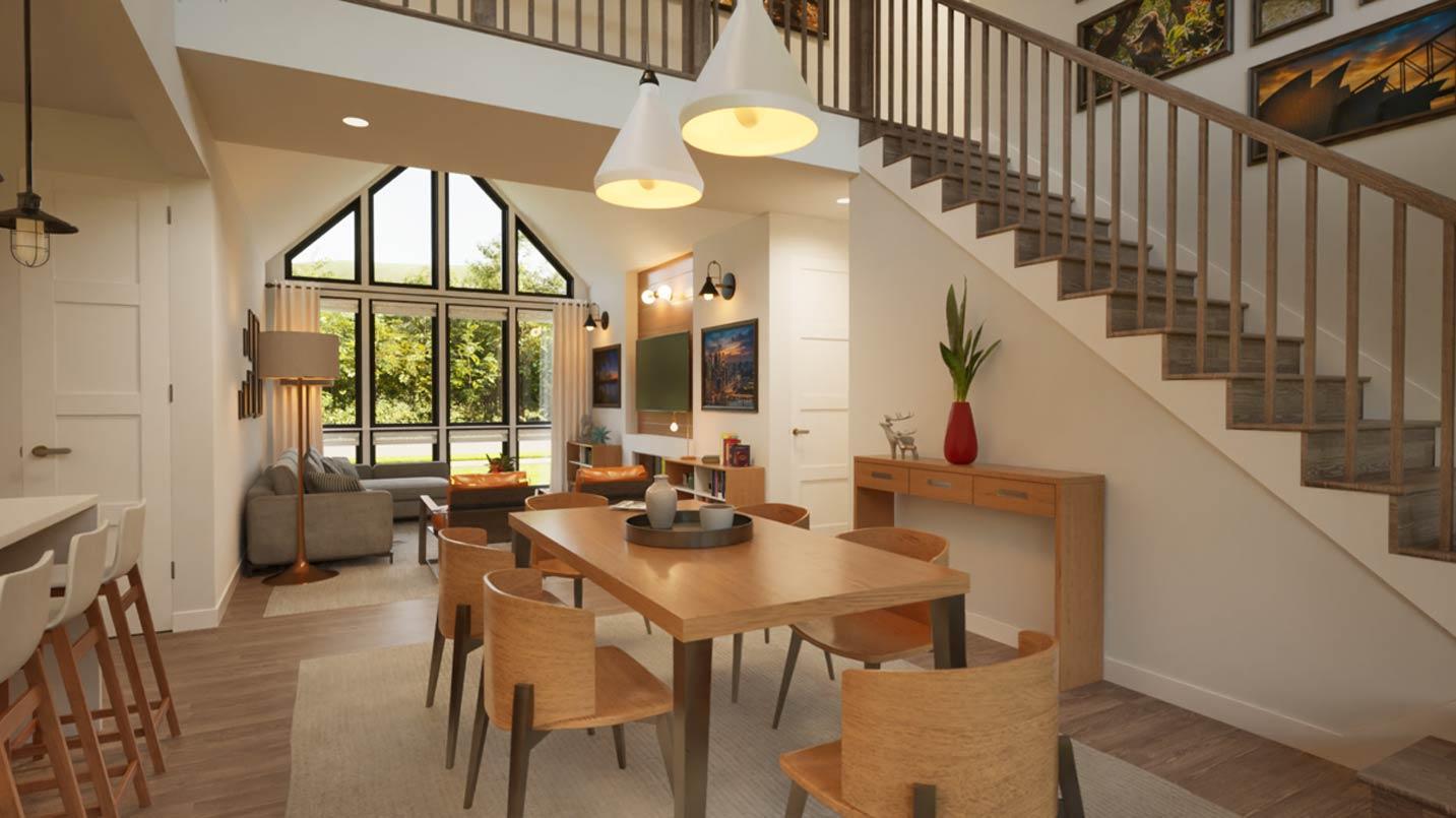 Open-concept living area with dining table, sectional sofa, fireplace, and large windows with vaulted ceiling.