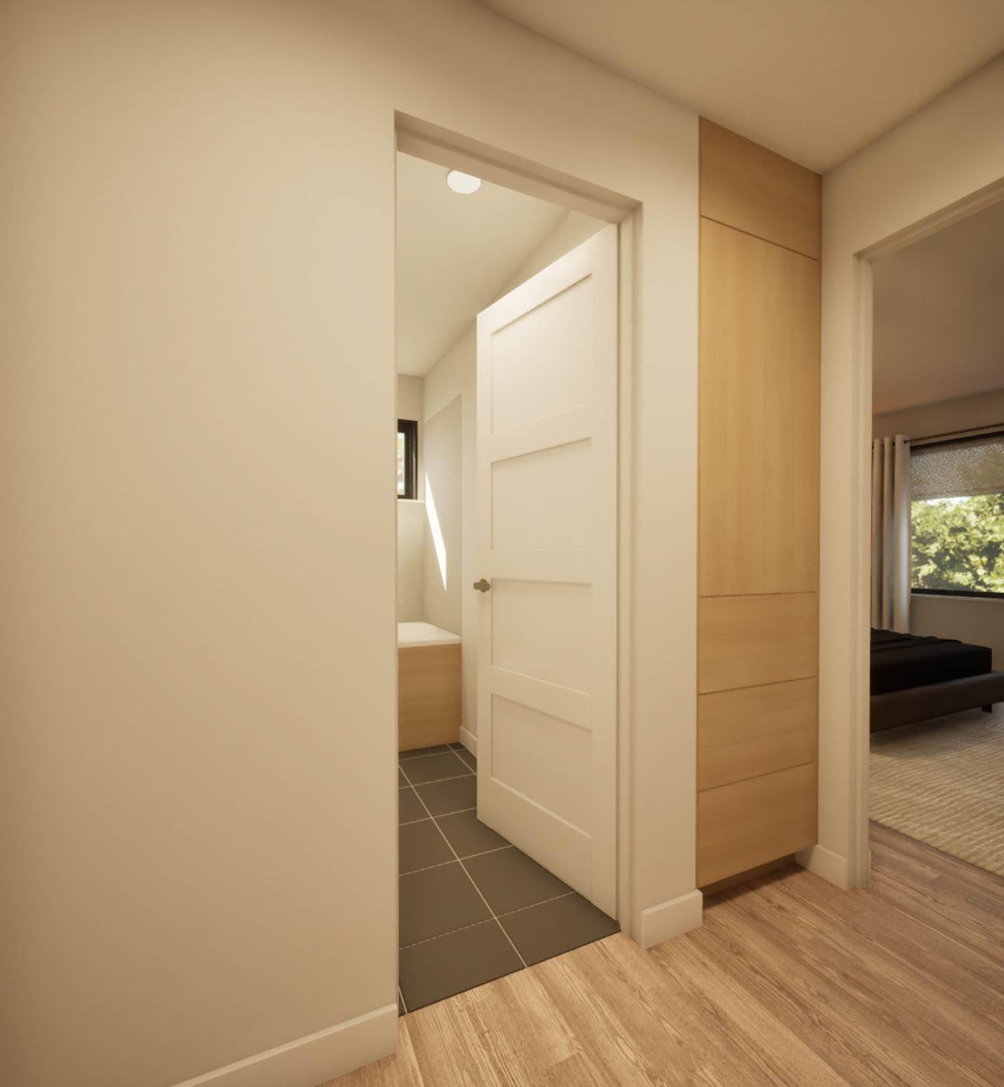 Interior view showing a hallway with a paneled door, built-in wood cabinetry, and an opening to a bathroom with tiled floor.