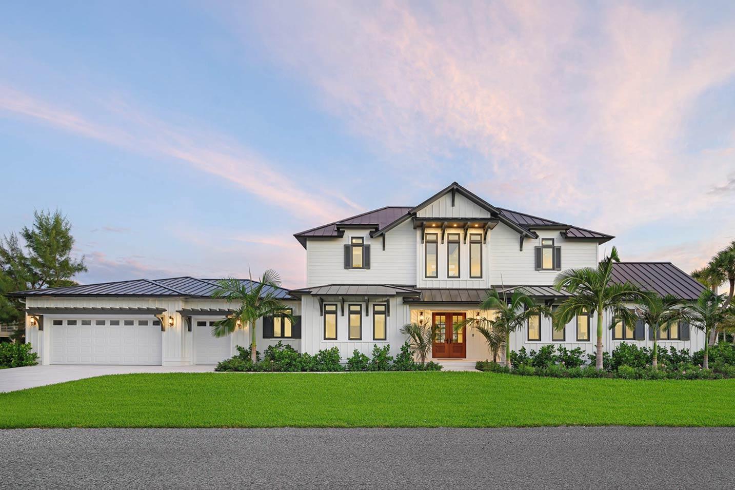 Modern Farmhouse style house plan exterior with metal roof, multiple gables, a three-car garage, and a covered entryway.