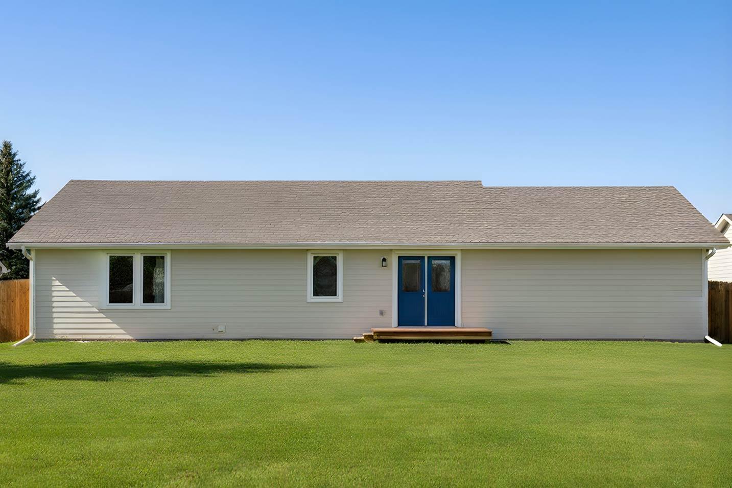One-story house plan exterior with neutral siding, a gabled roof, two windows, and double blue doors with a small wooden deck.