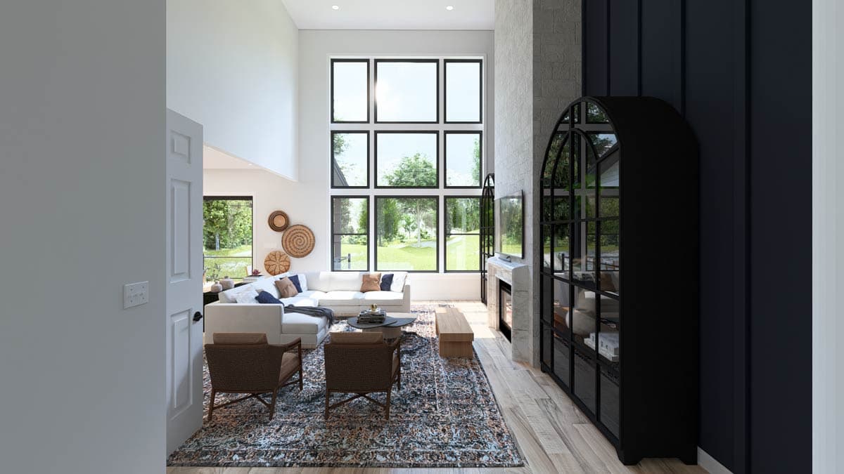 Living room with vaulted ceiling, large grid windows, fireplace, and sectional sofa.