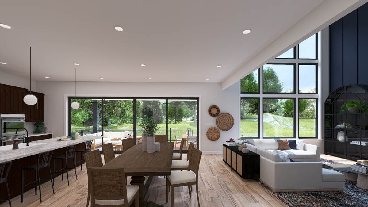 Open concept great room and kitchen with large windows, dining table, and island with seating.