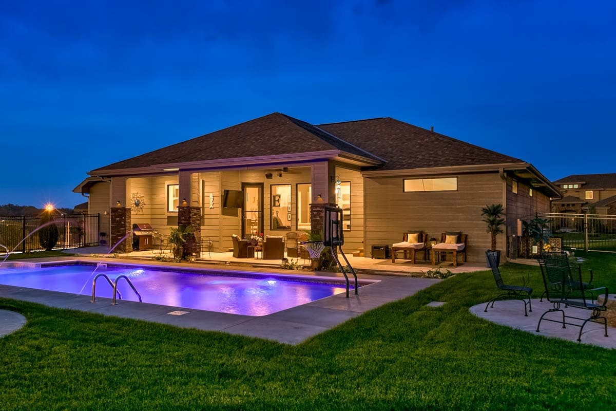 House plan exterior: Single-story home with covered patio, outdoor kitchen, and swimming pool.