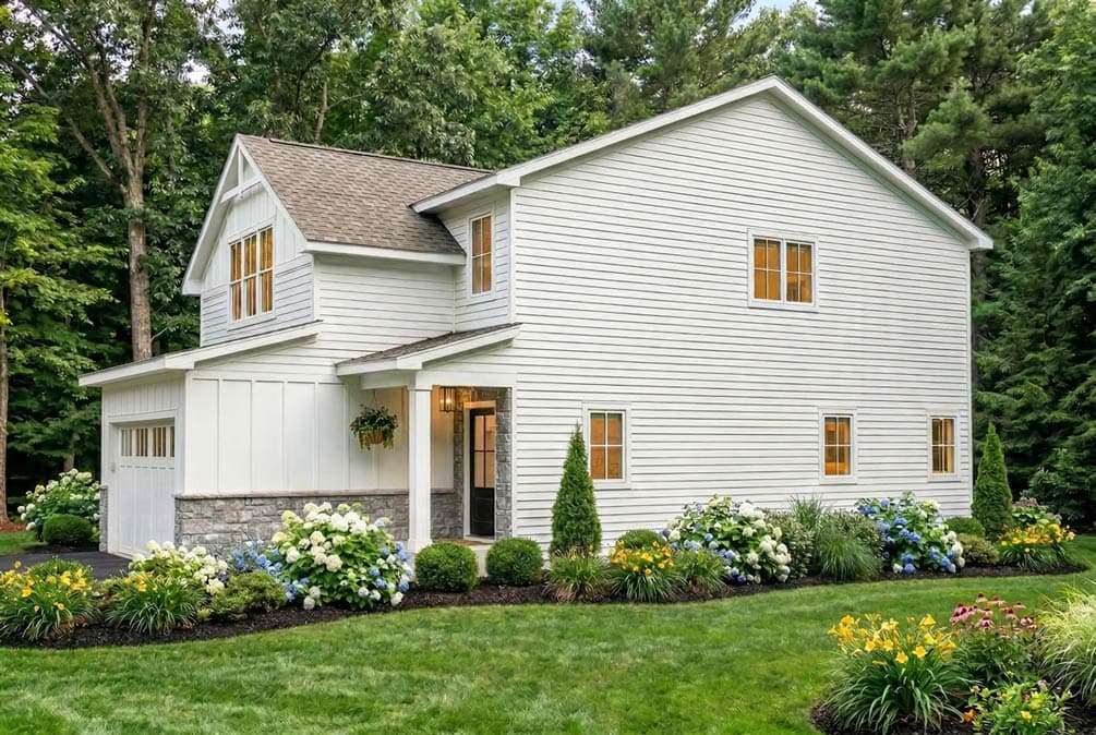 House plan exterior: two-story modern farmhouse with gabled dormer, covered entry, stone foundation, and attached garage.