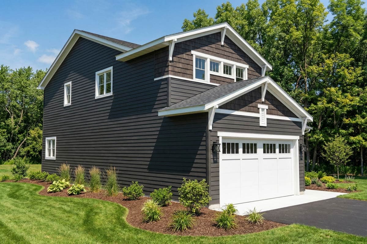 House plan exterior: Two-story dwelling with horizontal siding, shingled gables, dormers, and a two-car garage.