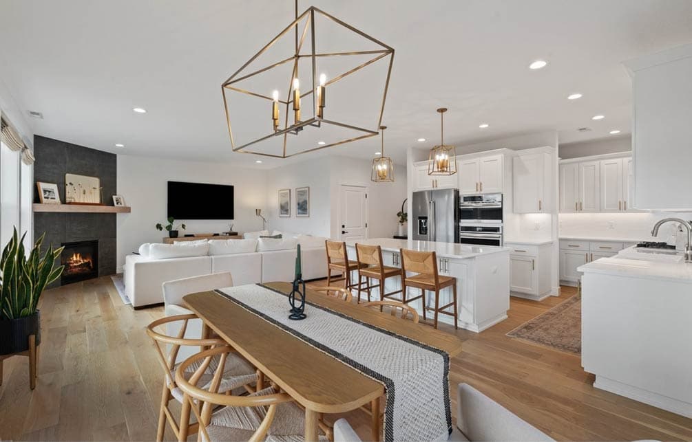 Open concept living area featuring a fireplace, large sectional sofa, island kitchen with bar stools, and dining area.