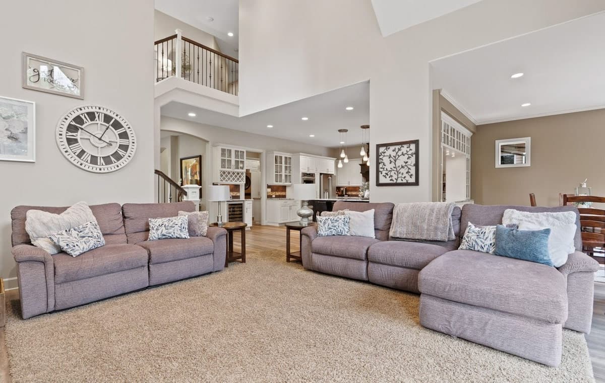 Open-concept living area with vaulted ceiling, U-shaped kitchen, and mezzanine overlooking the great room.