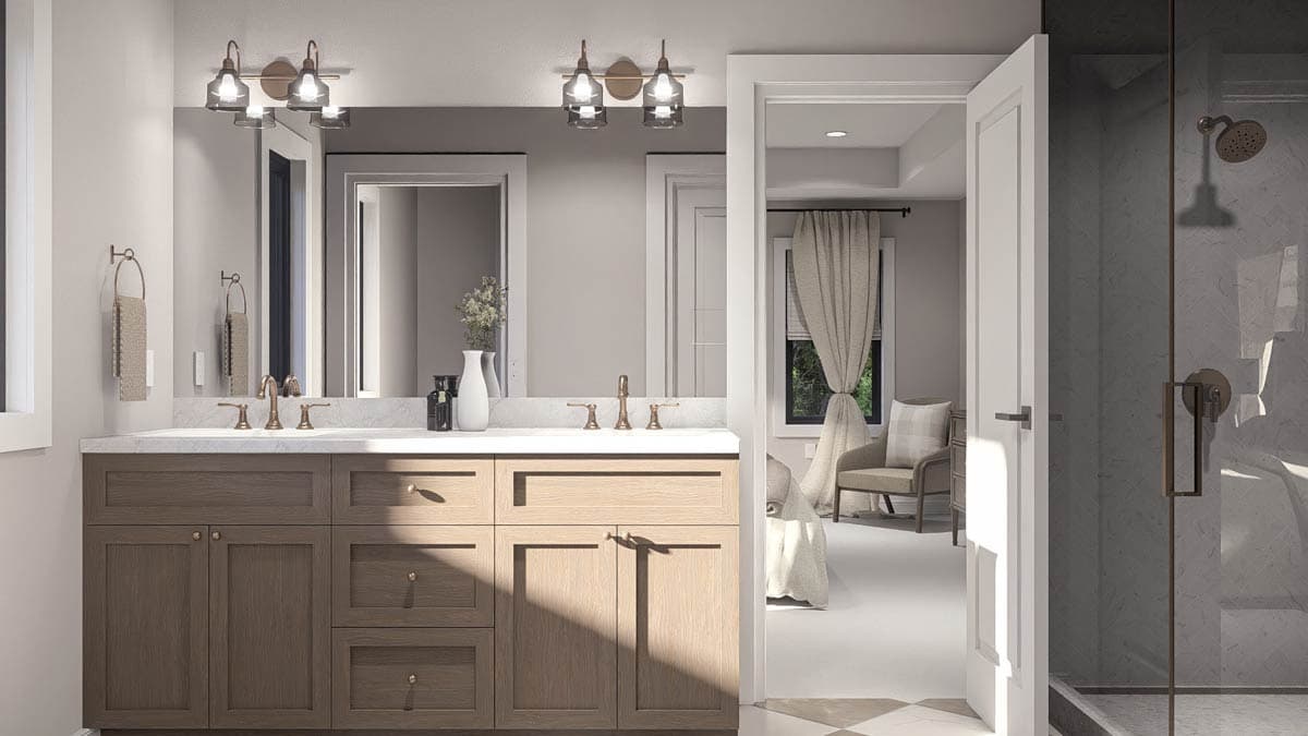 Bathroom with double vanity, glass-enclosed shower, and view into bedroom with armchair.