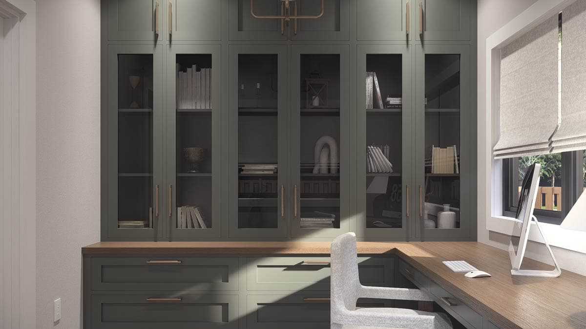 Built-in cabinetry with glass-front upper doors and lower drawers, adjoining a wooden desk with a computer.