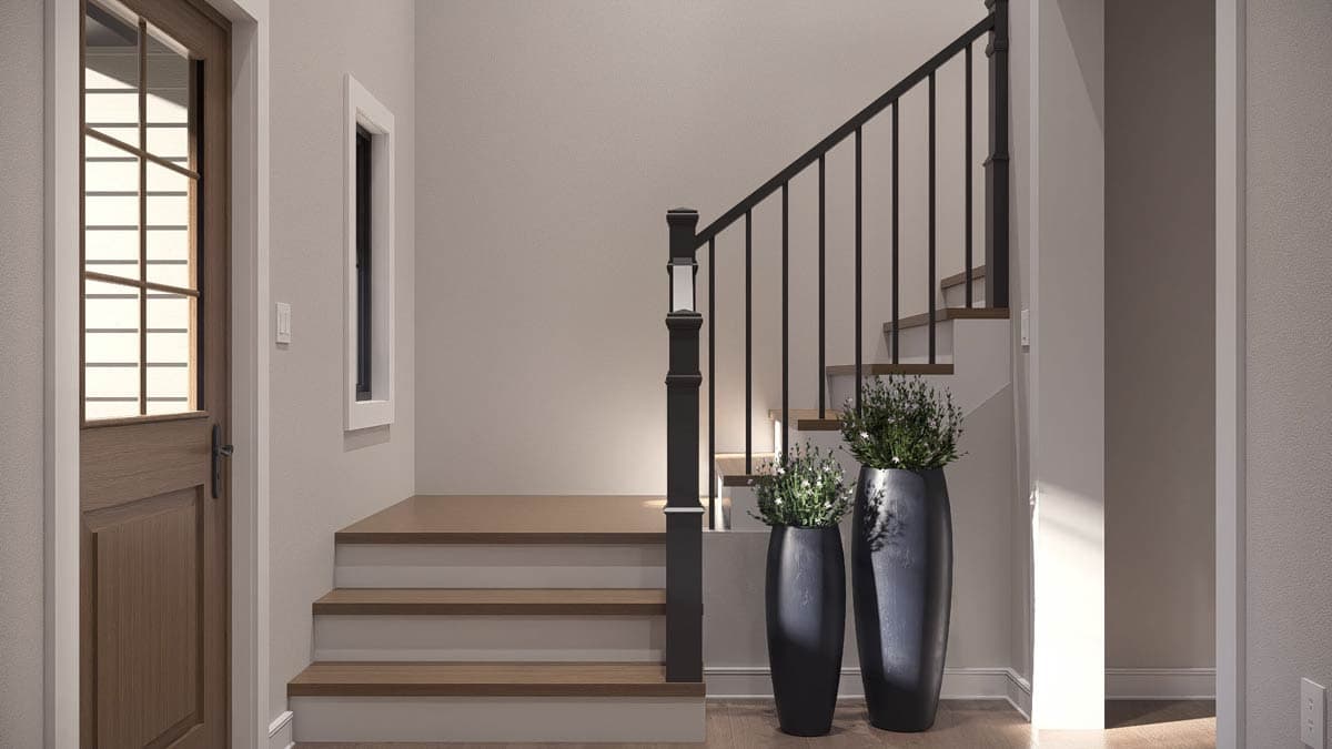 Interior view of staircase with wooden treads, black metal balusters, and decorative planters.