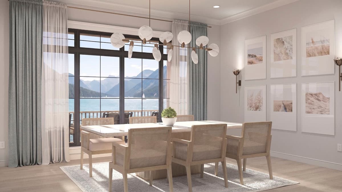 Dining room with large windows overlooking a bay, a rectangular table, cane-backed chairs, and wall art.