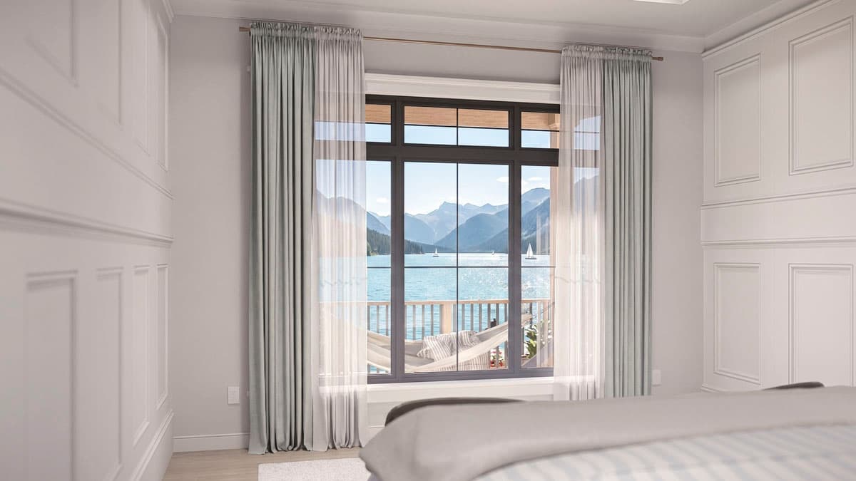 Interior view of a bedroom with wainscoting, showing a large window with a view of a lake, mountains, and sailboats.